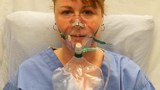 NIV-behandling er en form for respiratorbehandling med maske, hvor der kan tilføres ilt. Patienterne er ved bevidsthed og kan selv trække vejret.  Foto: Wikimedia Commons